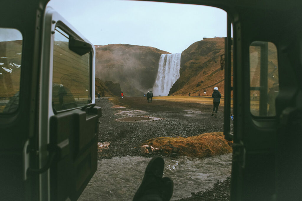 Person looking out van doors at a waterfall